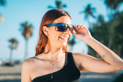 a woman smiling wearing Torege sunglasses in a sunny outdoor setting